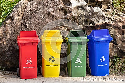 Different colored trash containers for garbage separation with sign and icon near the beach for tourist Stock Photo