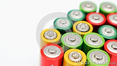 Different colours of batteries on white background. Close up of positive ends batteries, selective focus. Used battery for Stock Photo