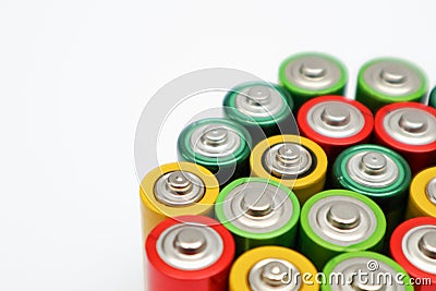 Different colours of batteries on white background. Close up of positive ends batteries, selective focus. Used battery for Stock Photo