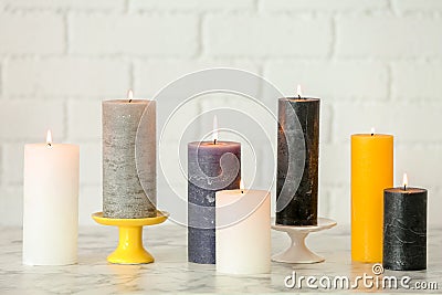 Different decorative wax candles on table Stock Photo