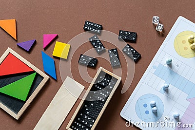 Different desktop games, figures, dices, parts on the brown table. Home entertaiment, indoor games. Stock Photo