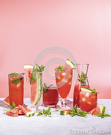 Different elegant glasses with watermelon cocktail. Splash, splatter, water drops on the pink background Stock Photo