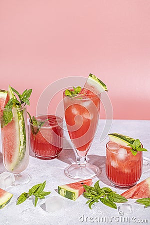 Different elegant glasses with watermelon cocktail. Splash, splatter, water drops on the pink background Stock Photo