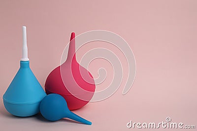 Different enemas on pink background, space for text. Medical treatment Stock Photo