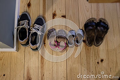 Different family shoes, bigger and smaller on a hardwood interior house Stock Photo