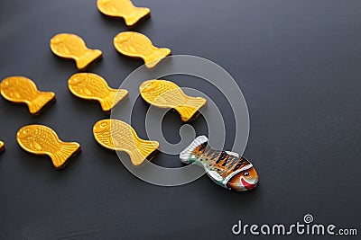 different fish swimming opposite way of identical ones. Courage and success concept. Blackboard background. Stock Photo