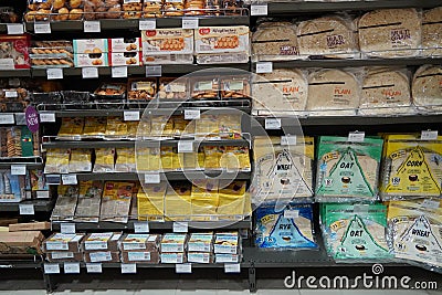 Different fresh bread on the shelves in bakery. Interior of a modern grocery store showcasing the bread aisle with a variety of Editorial Stock Photo