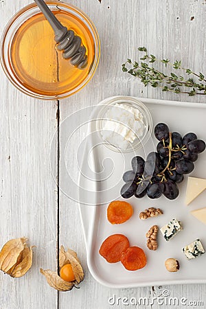 Different fruit and cheese with honey and sprig of thyme Stock Photo