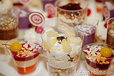 Different fruit desserts with fruits in glasses on the table. Restaurant presentation, food, party concept Stock Photo