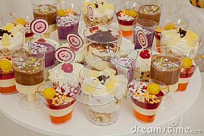 Different fruit desserts with fruits in glasses on the table. Restaurant presentation, food, party concept Stock Photo