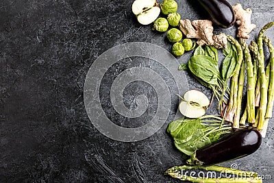 Different green fresh seasonal vegetables on black table top background Stock Photo