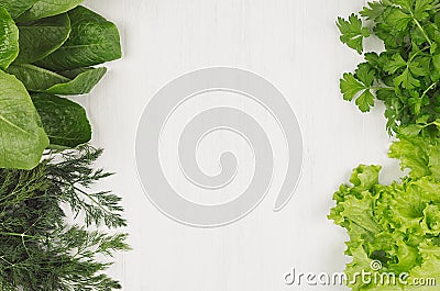 Different green sheaves greens for spring salad on white wooden background, top view, decorative frame. Stock Photo