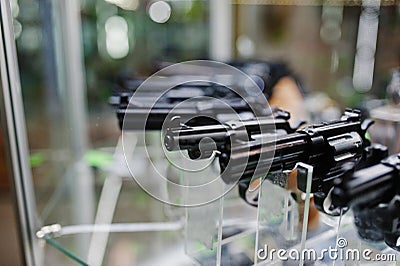 Different guns and revolvers on shelves store weapons on shop ce Stock Photo