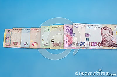 Different hryvnias on a blue background. Place for text. Copy of space. Hryvnia arranged in order of growth. Stock Photo
