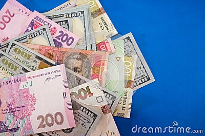 Different hryvnias and dollars on a blue background. Copy space. Stock Photo