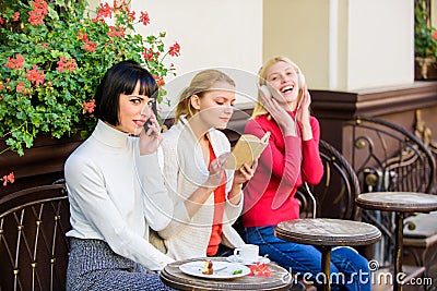 Different interests. Hobby and leisure. Group pretty women cafe terrace entertain themselves with reading speaking and Stock Photo
