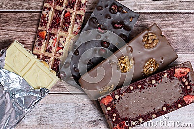 Different kinds fof chocolate bars on vintage wooden background. Stock Photo