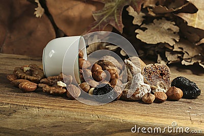 Different kinds of nuts and white cup, hazelnuts, almonds, walnut and dried fruits figs, plums. Vegetarian food Stock Photo