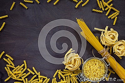 Different kinds of pasta on the kitchen wooden table. The concept of Italian food. Stock Photo