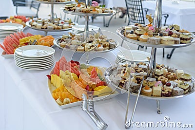 Various pastries and fruits displayed on silver trays Stock Photo