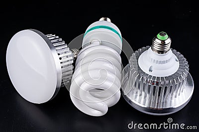 Different light bulbs and fluorescent lights on a wooden table. New types of lighting Stock Photo