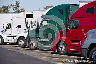 Different make and moders of big rigs semi trucks stand in row o Stock Photo