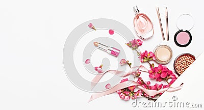 Different makeup cosmetic. Ball blush rouge lipstick concealer bottle of perfume makeup brush spring pink flowers in white gift Stock Photo