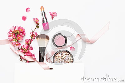 Different makeup cosmetic. Ball blush rouge lipstick concealer bottle of perfume makeup brush spring pink flowers in Stock Photo