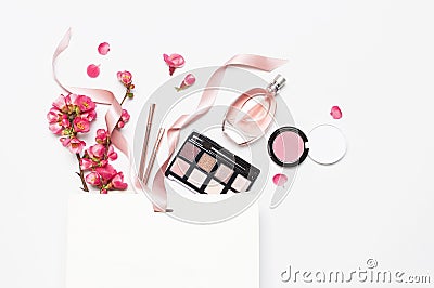 Different makeup cosmetic. Ball blush rouge lipstick concealer bottle of perfume makeup brush spring pink flowers in Stock Photo
