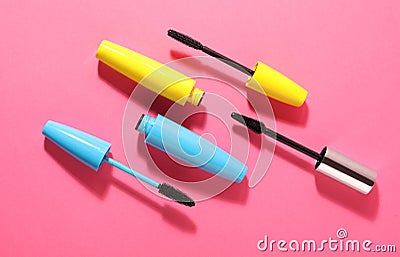 Different mascaras on bright pink background, flat lay Stock Photo