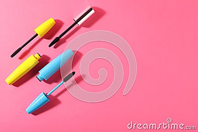 Different mascaras on bright pink background, flat lay. Space for text Stock Photo