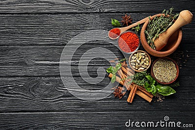 Different natural spices and herbs on black wooden table, flat lay. Space for text Stock Photo