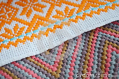 Different orange, pink and blue patterns of embroidery on white fabric Stock Photo