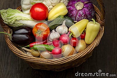 Different Organic Fruits and vegetables in basket on wooden table back Stock Photo