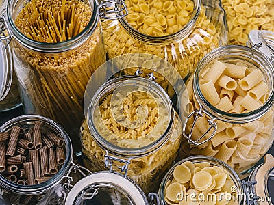 Different pasta in large glass jars Stock Photo