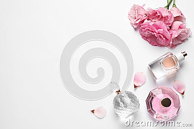 Different perfume bottles and flowers on background, top view Stock Photo