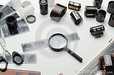 Different photographic films, scissors and magnifying glass on white background Stock Photo
