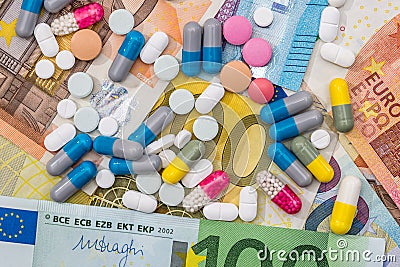 Different pills above euros bills. Stock Photo