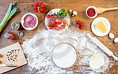 Different pizza ingredients, vegetables and dough on wooden tabletop Stock Photo