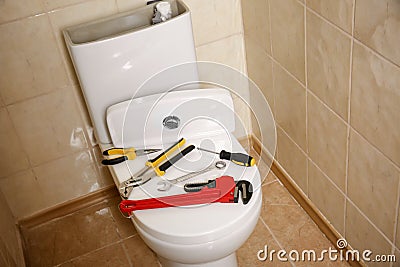 Different plumber`s tools on toilet seat lid Stock Photo
