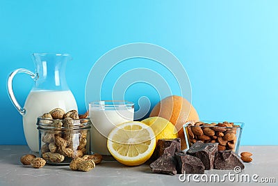 Different products on stone table against light blue background. Food allergy concept Stock Photo