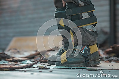 Different safety equipment for arborist or arborists such as boots, shoes, knee and shin guards on safety trousers. Detail of Stock Photo
