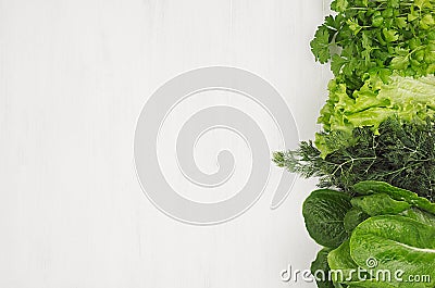 Different sheaves greens on white wooden background as decorative border, top view. Stock Photo