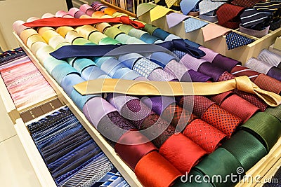 Different silk neckties on shelves Stock Photo