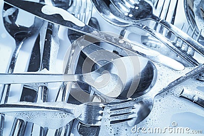 Different silverware in foam, flat lay. Toned in blue Stock Photo