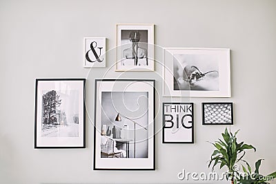 Different size framed photos hanging on the gray wall. Editorial Stock Photo