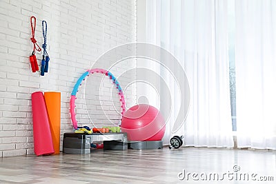 Different sports equipment near brick wall in gym. Space for text Stock Photo