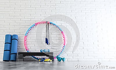 Different sports equipment near white brick wall in gym Stock Photo