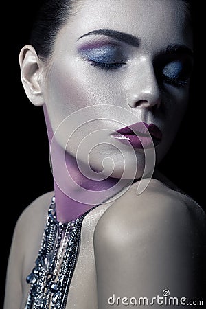 Different style of beauty. young beautiful fashion model with silver, purple, blue makeup and shiny silver jewelry chain on her fa Stock Photo