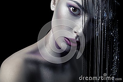 Different style of beauty. young beautiful fashion model with silver, purple, blue makeup and shiny silver jewelry chain on her fa Stock Photo